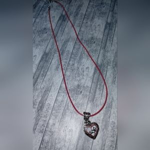 Silver heart pendant on red rope